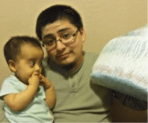 A father with his son holding a diaper cake