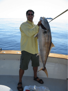 Man with the fish he caught on a boat