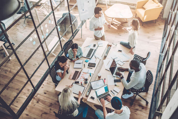 A group of co-workers collaborating at a large desk