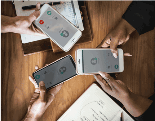 Aerial shot above a table with three cellphones calling into a conference call