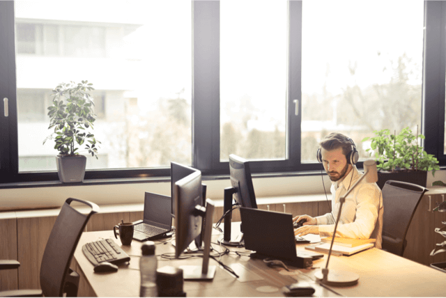 Men working at a desk with his headphone