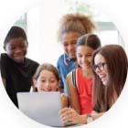 teacher with students surrounding her while on the computer