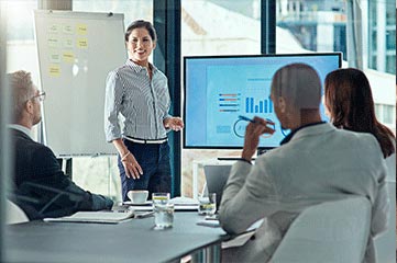 Frau präsentiert eine aufgenommene Screen-Sharing-Präsentation in einem modernen Konferenzraum.