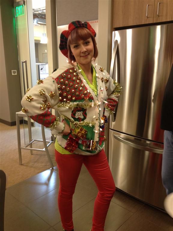 A woman in an ugly Christmas sweater standing in the kitchen